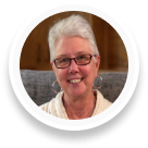 A circle profile picture featuring an image of a client Nancy, the person who is giving the video testimonial featured in this section.